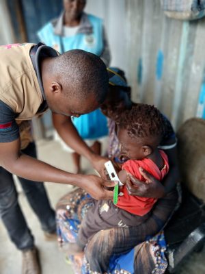 Frank Kaburia, a CFK Nutritionist, tests for malnutrition in Kibera